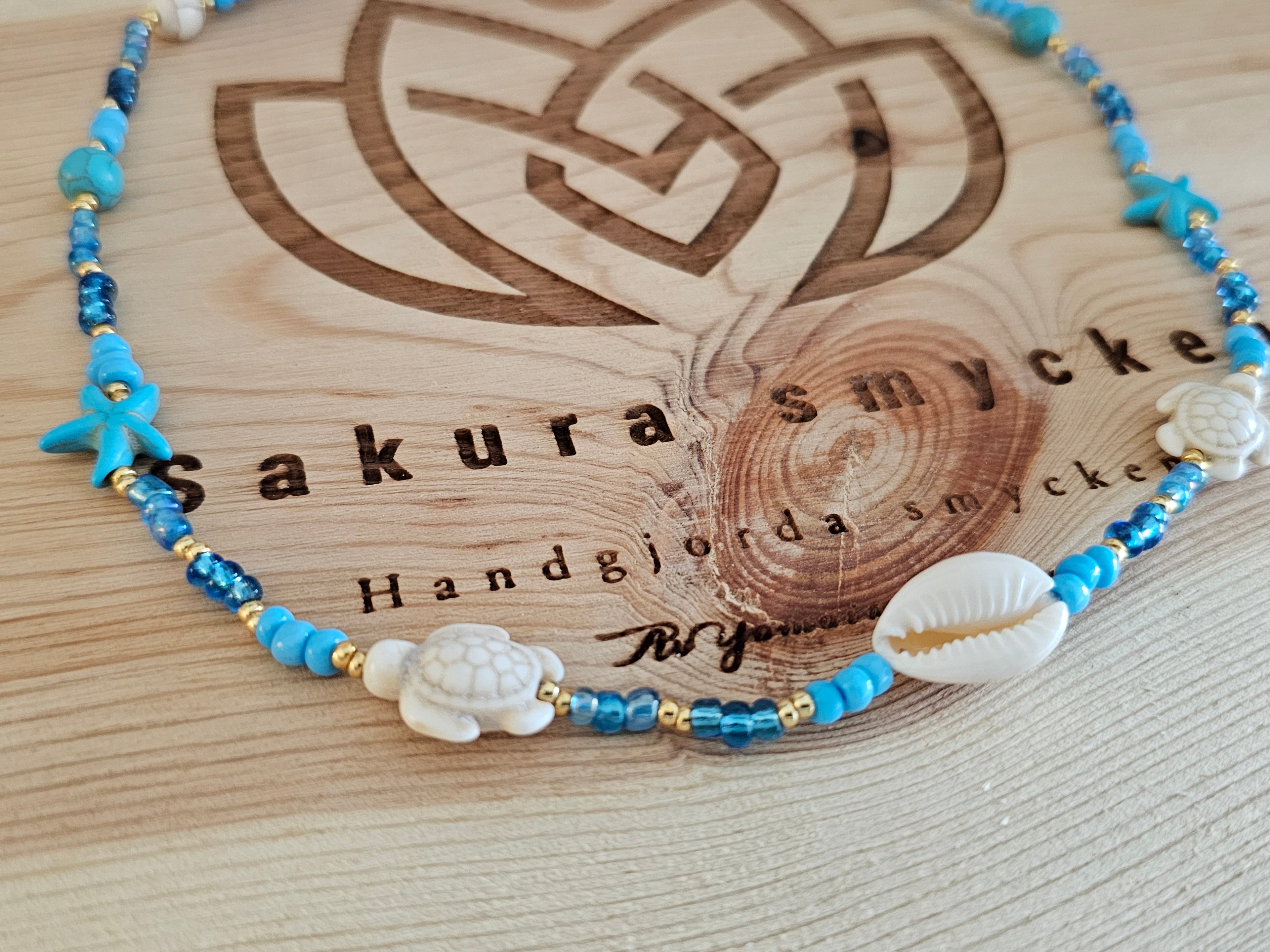 Havsinspirerat pärlhalsband med snäcka och sköldpaddor